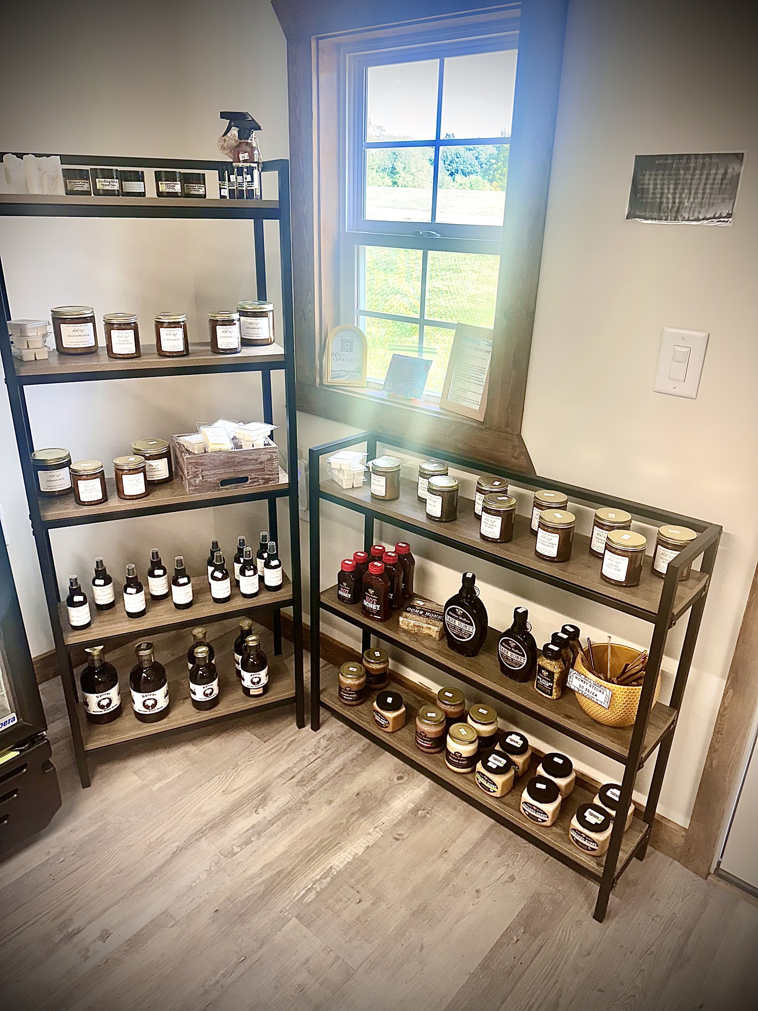Shelves inside the Farmstand filled with jars of tallow and candles, and locally made pantry goods from small businesses.