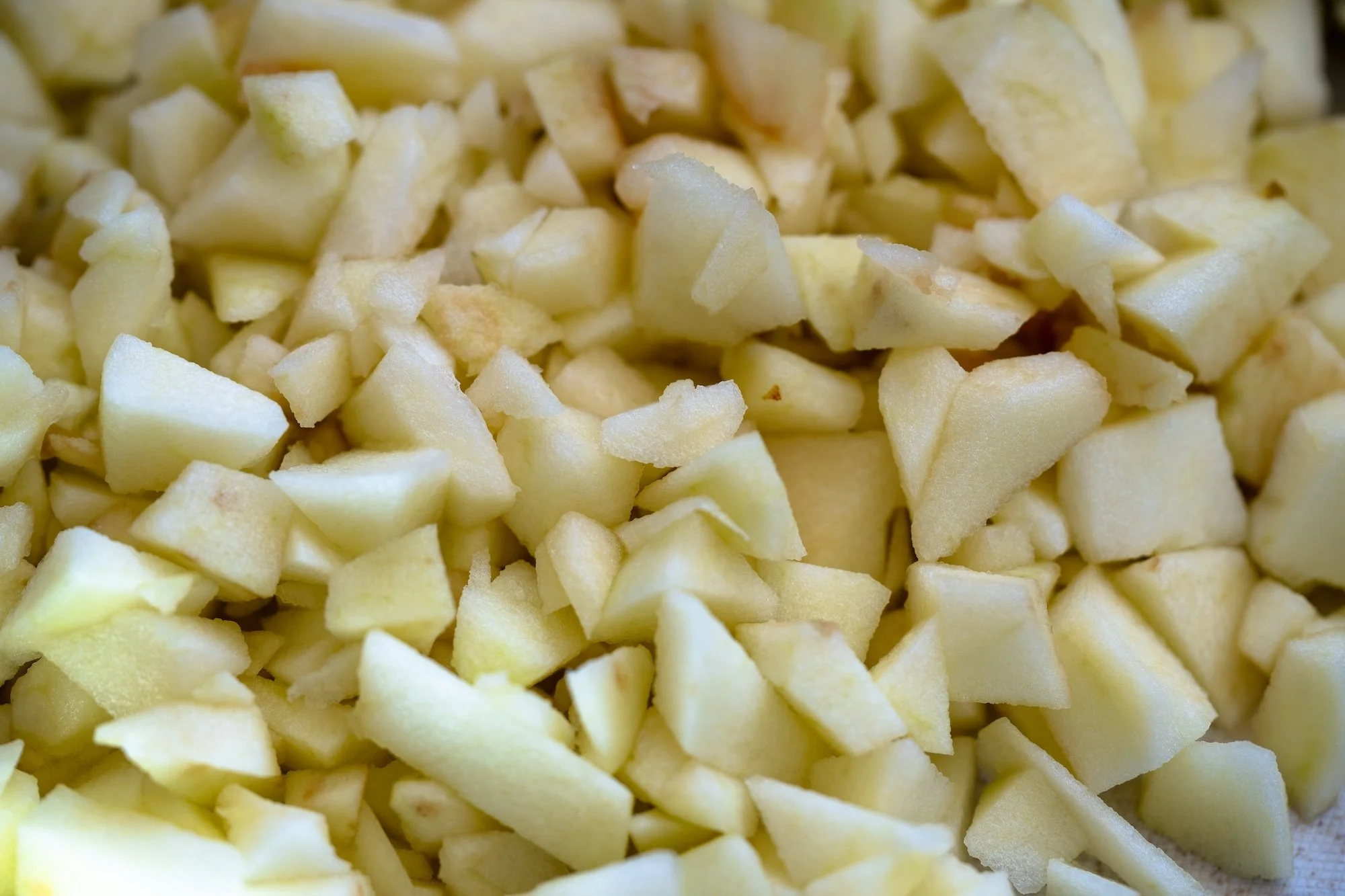 Close-up of finely diced peeled apples, cut into small even pieces for baking.