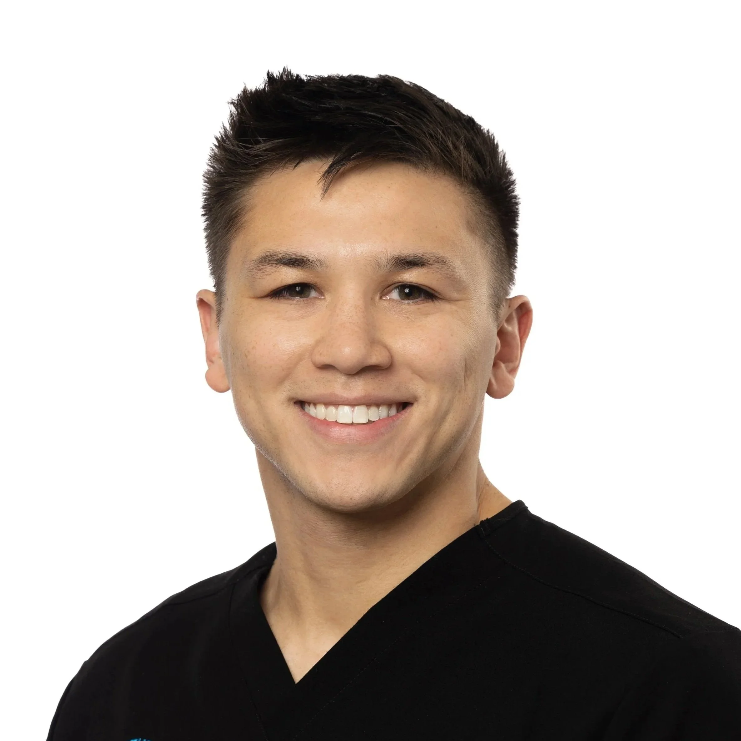 Portrait of young man with short dark hair, smiling, wearing a black shirt, against a white background. James Kunzler. Chicago Dental Anesthesia, Sedation, Illinois.