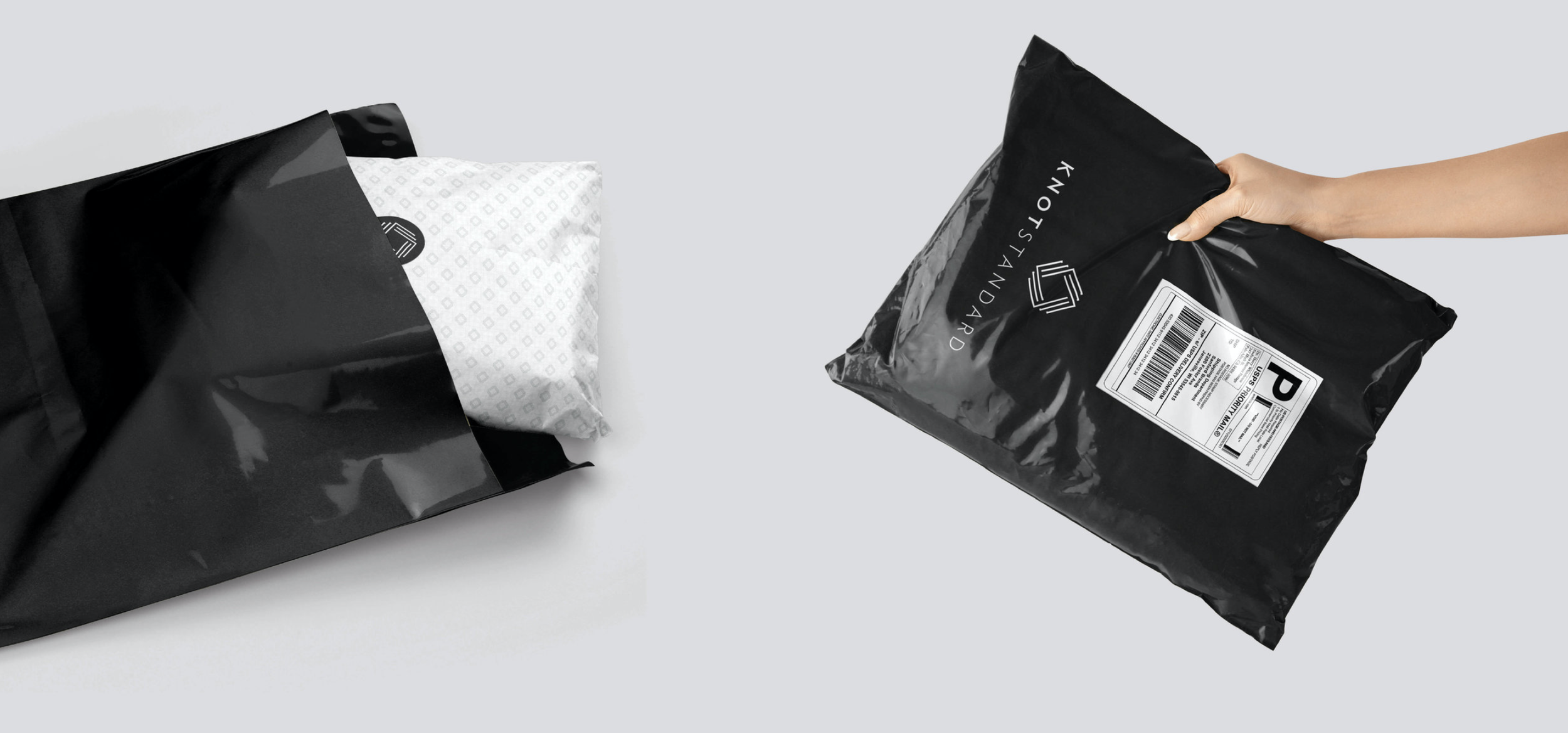 A person holding a black padded envelope with a shipping label, with a package on a white surface.