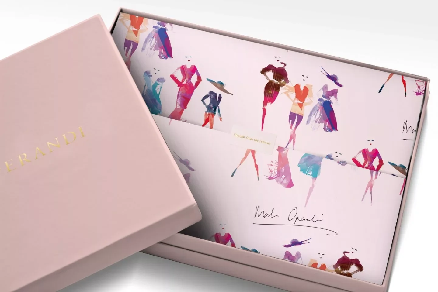 A pink box with gold text and an inside illustration of colorful fashion silhouettes of women in dresses and skirts, signed with the name Mark Opdahl.
