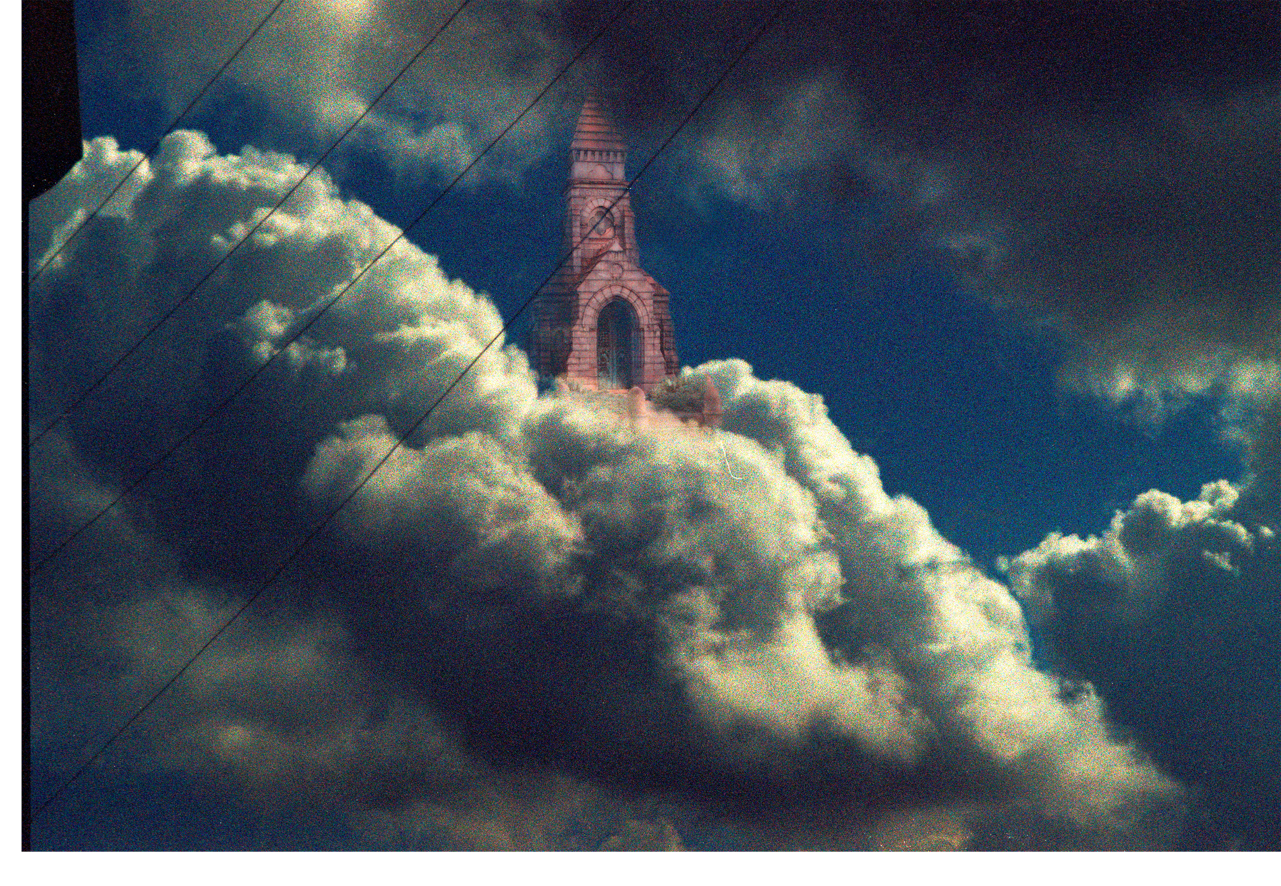 A tall mausoleum emerging from thick, fluffy clouds in the sky during daytime, with visible power lines crossing in front of the scene. Shot on Kodak Portra 800 35mm 