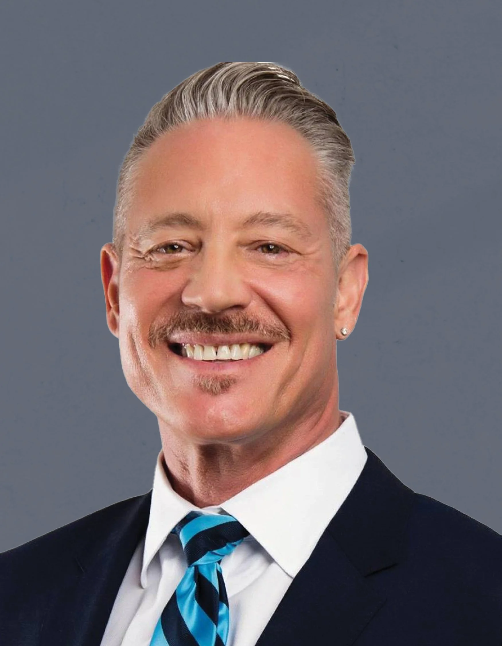 Headshot of a smiling man with gray hair, a mustache, and a goatee, wearing a dark suit, white shirt, and a blue striped tie, against a gray background.