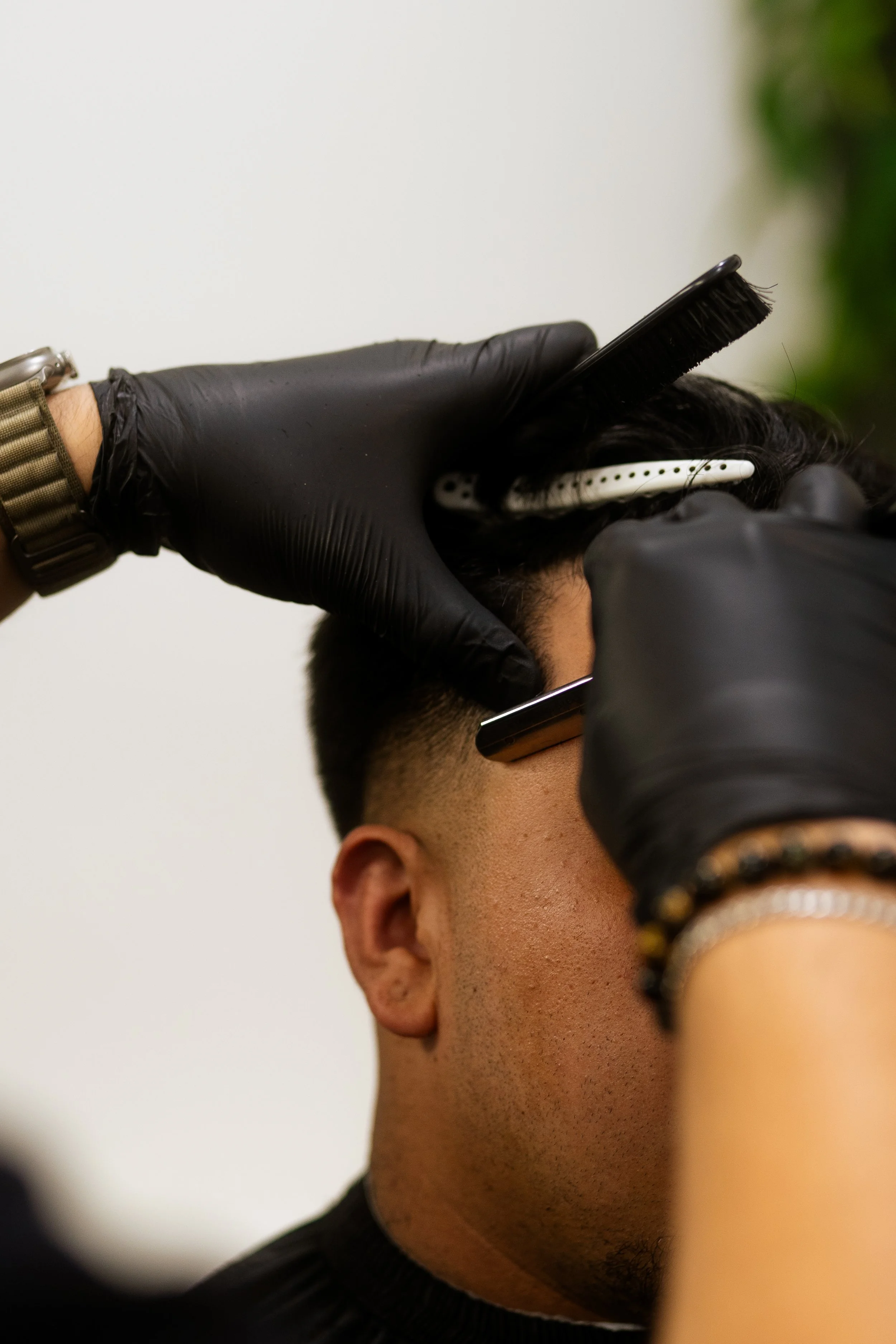 Barber using scissors and comb to cut a man's hair.