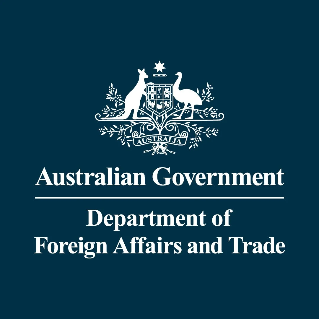 The logo of the Australian Government Department of Foreign Affairs and Trade, featuring a shield with various symbols, a kangaroo on the left, a emu on the right, and a star above the shield, all on a dark blue background.