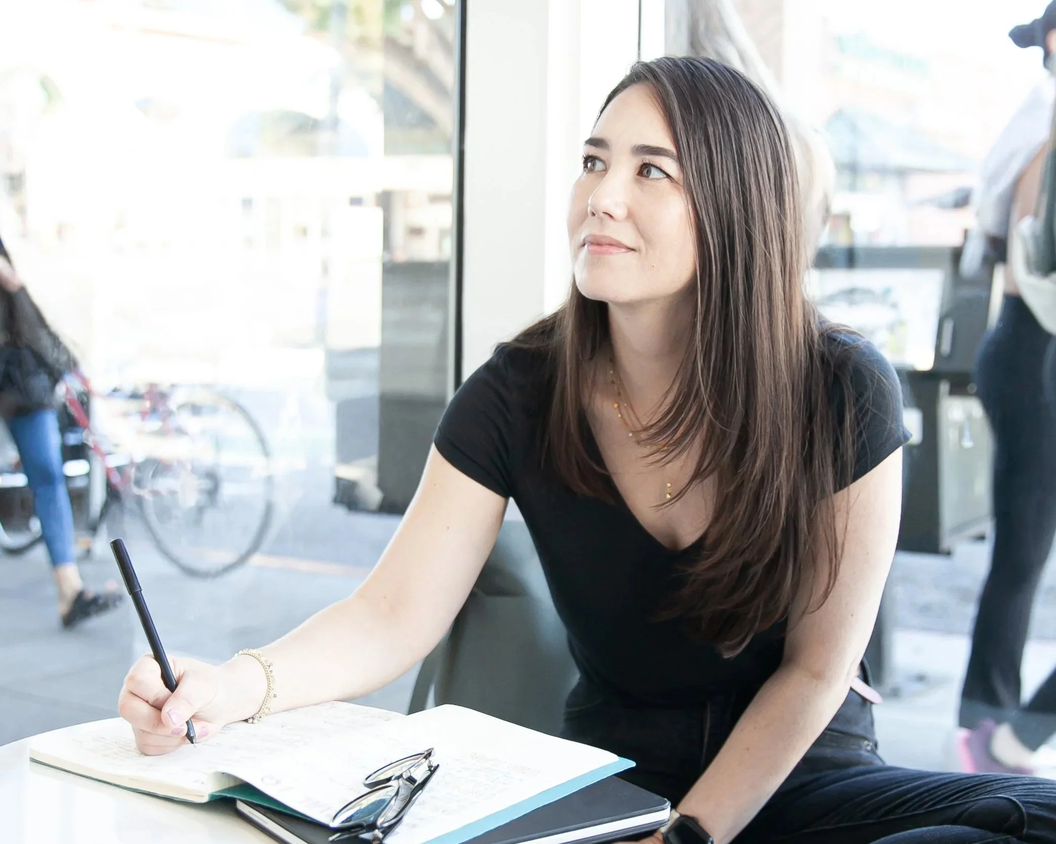 The Warm Edit founder writing in a notebook at a table