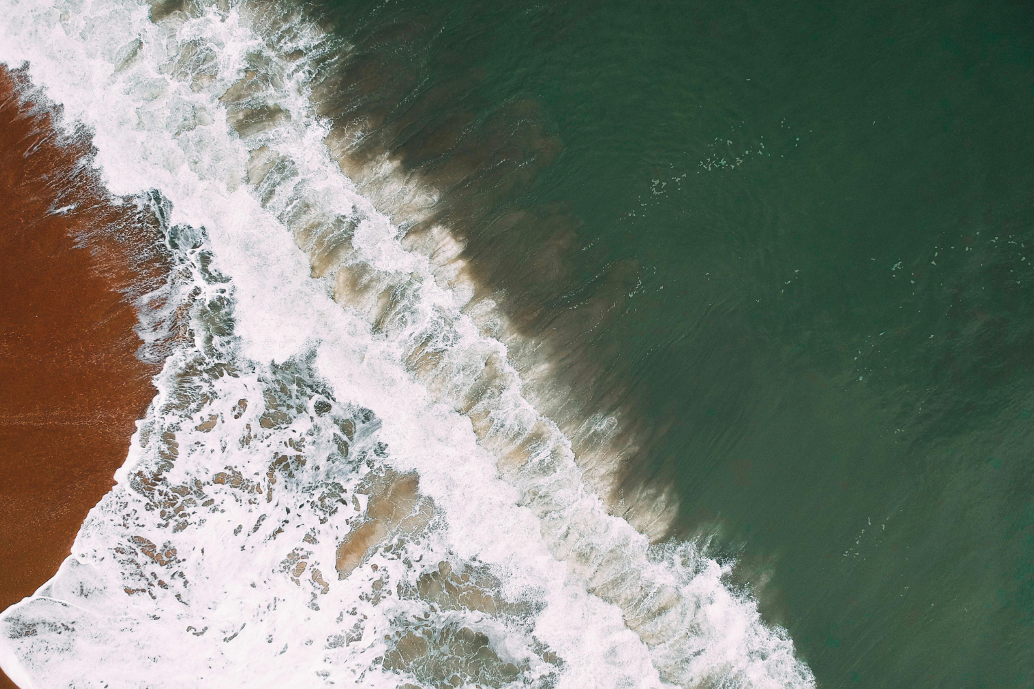An abstract close-up of a single blue ocean wave curling with white sea foam, symbolizing the process of allowing emotions to move through without resistance.