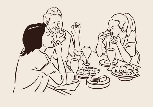 Three women sitting at a table enjoying snacks and drinks, laughing and talking.