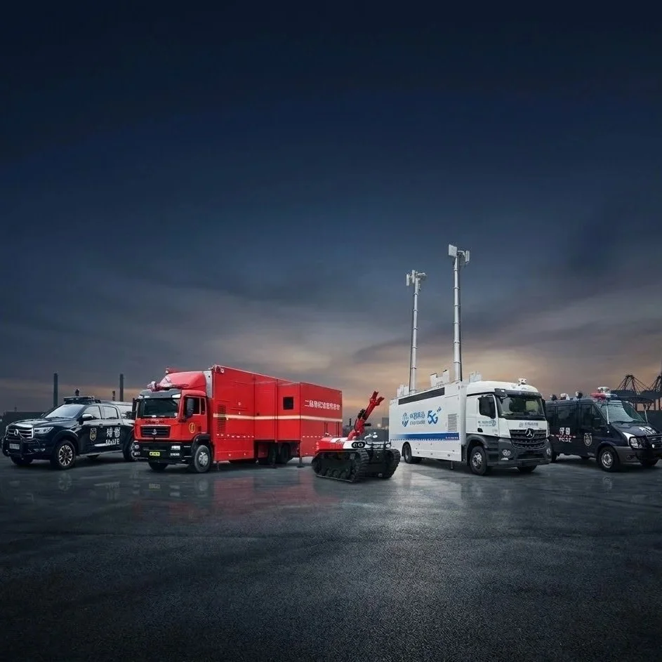 A lineup of emergency and rescue vehicles at sunset, including police cars, a fire truck, a mobile command center, and a robotic rescue vehicle with antennas and tracks.