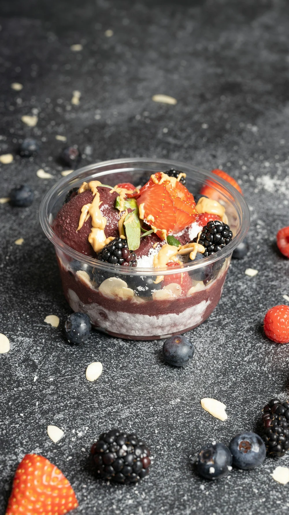 Açaí bowl i glass med granola, bjørnebær og toppinger