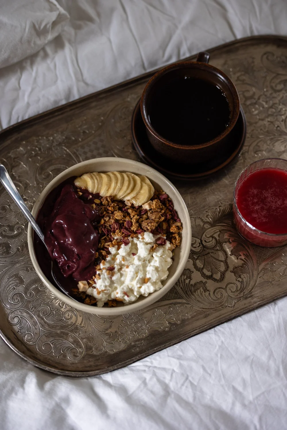 Açaí bowl med granola, cottage cheese og banan på frokostbrett med en kopp kaffe, servert som kos innendørs
