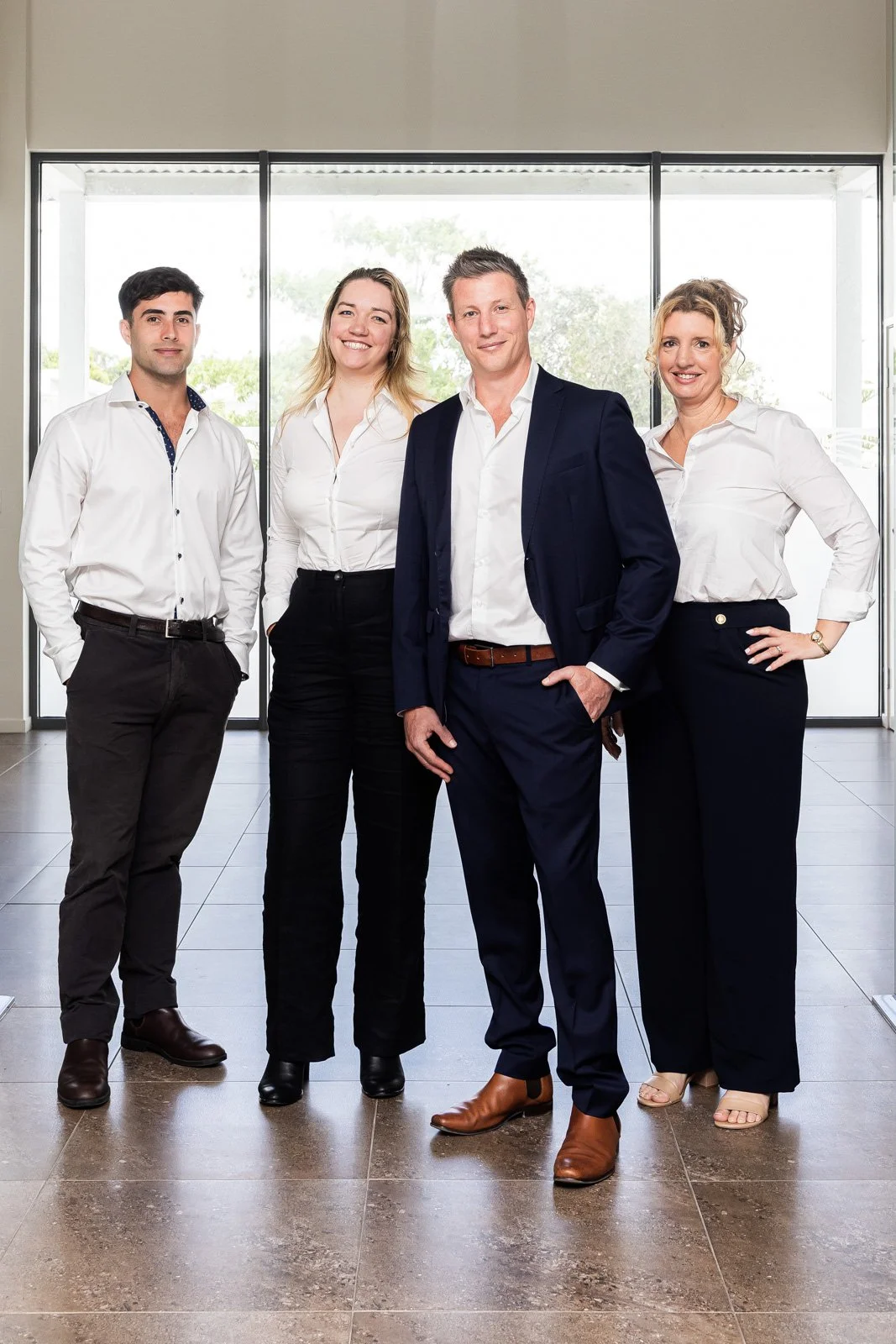 The Queensland Capital Solutions senior team standing together in a bright, modern office.