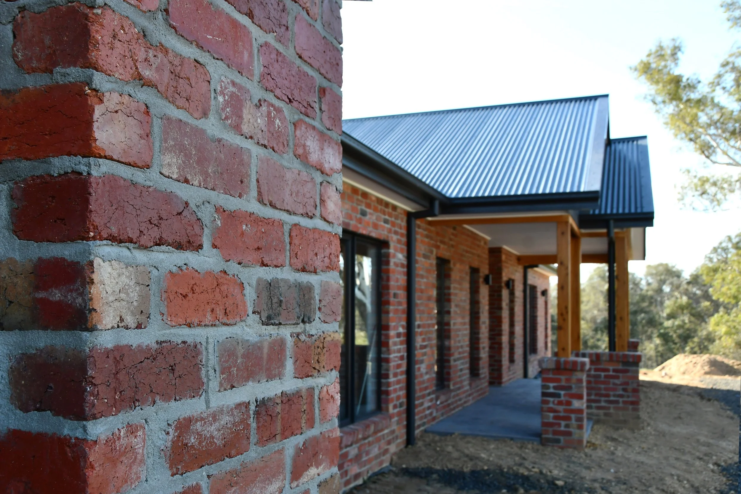 red brick rural home with tin roof