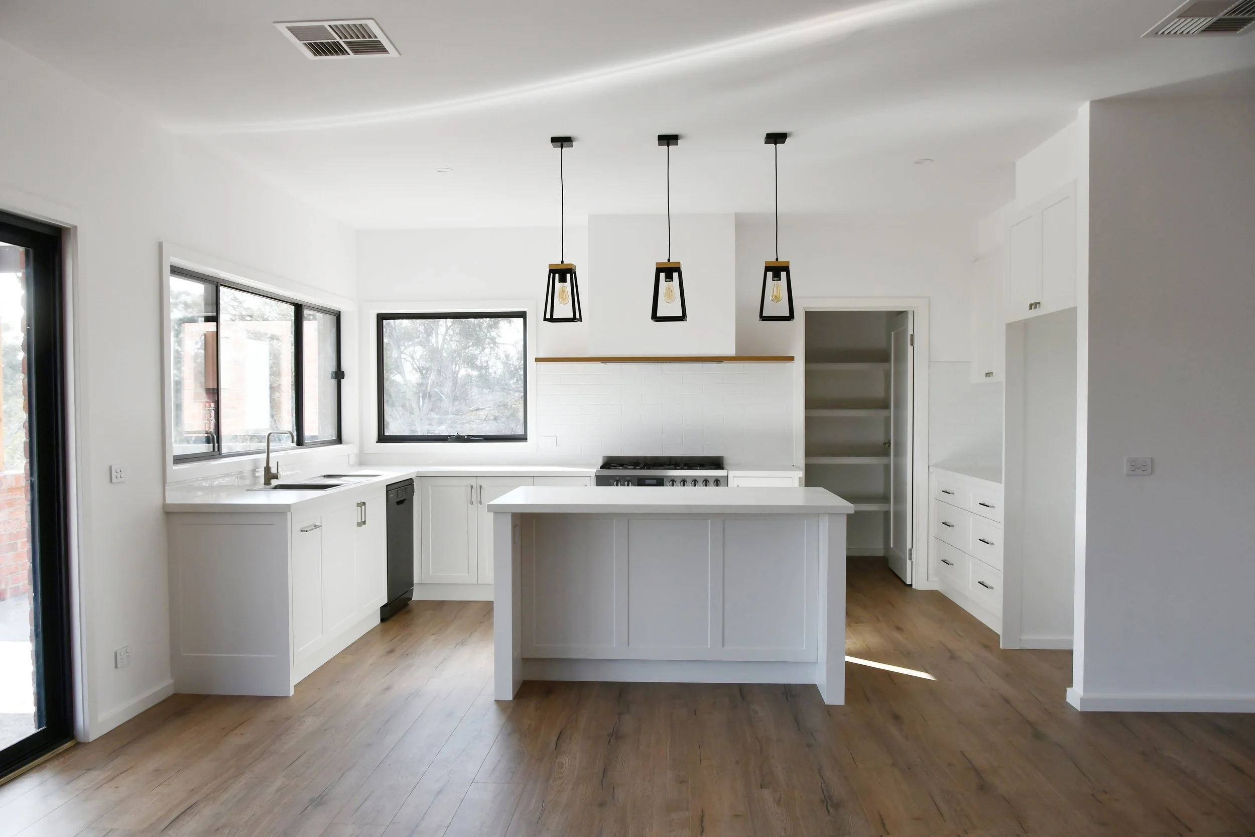 clean modern white kitchen large window and pendant lighting