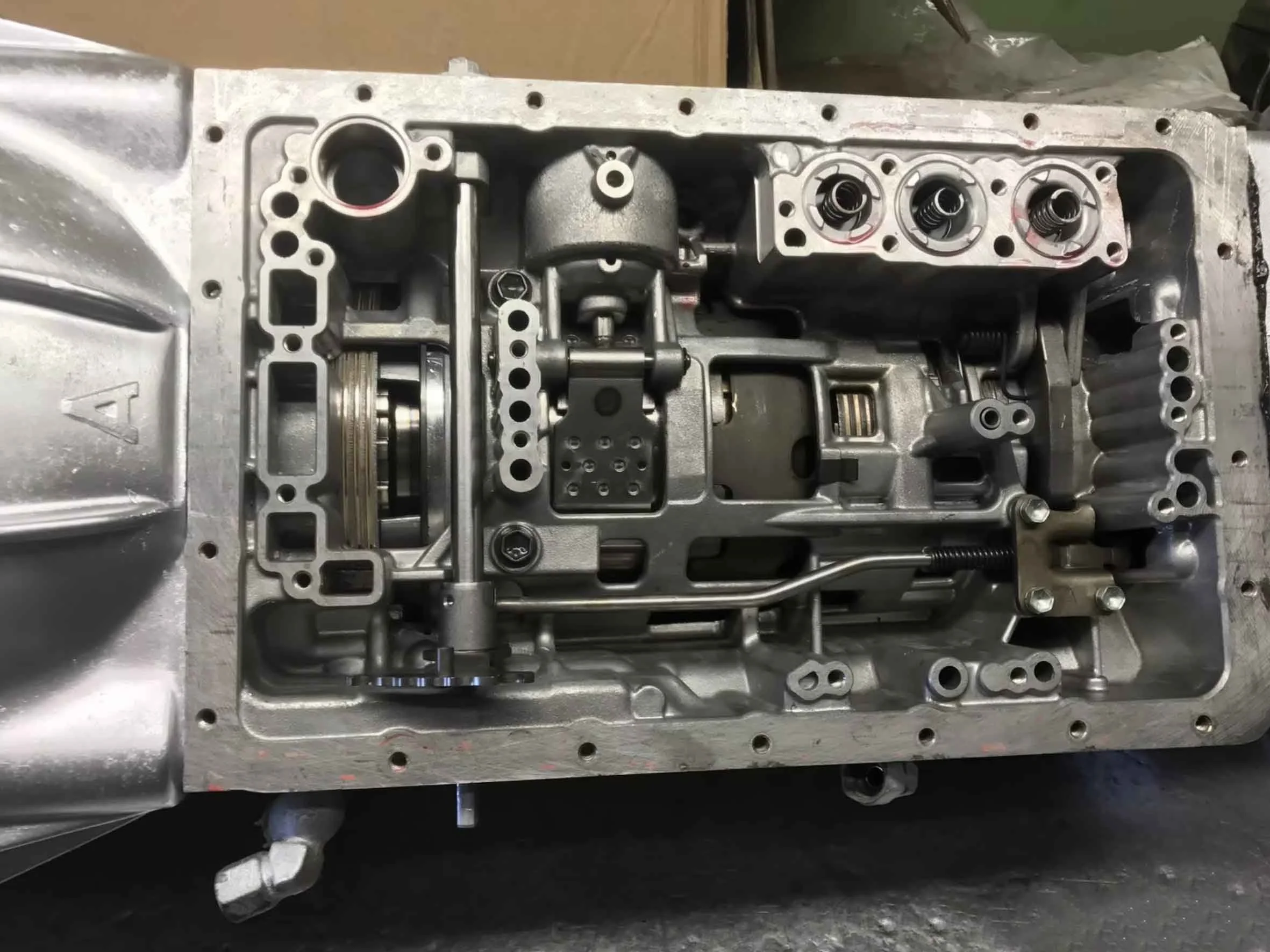 Automotive transmission system with visible gears, levers, and mechanical components inside a metal casing.