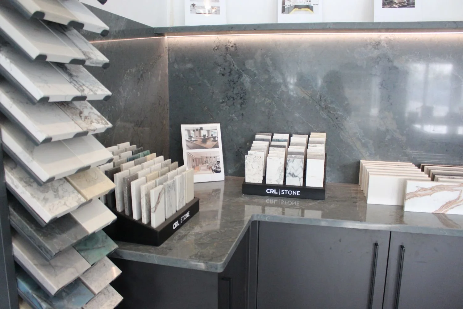 Display of countertop samples and catalogs of marble and stone materials in a showroom.