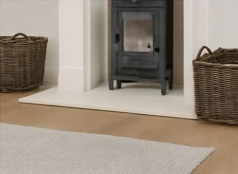 A black wood stove with two wicker baskets on either side in a living room.