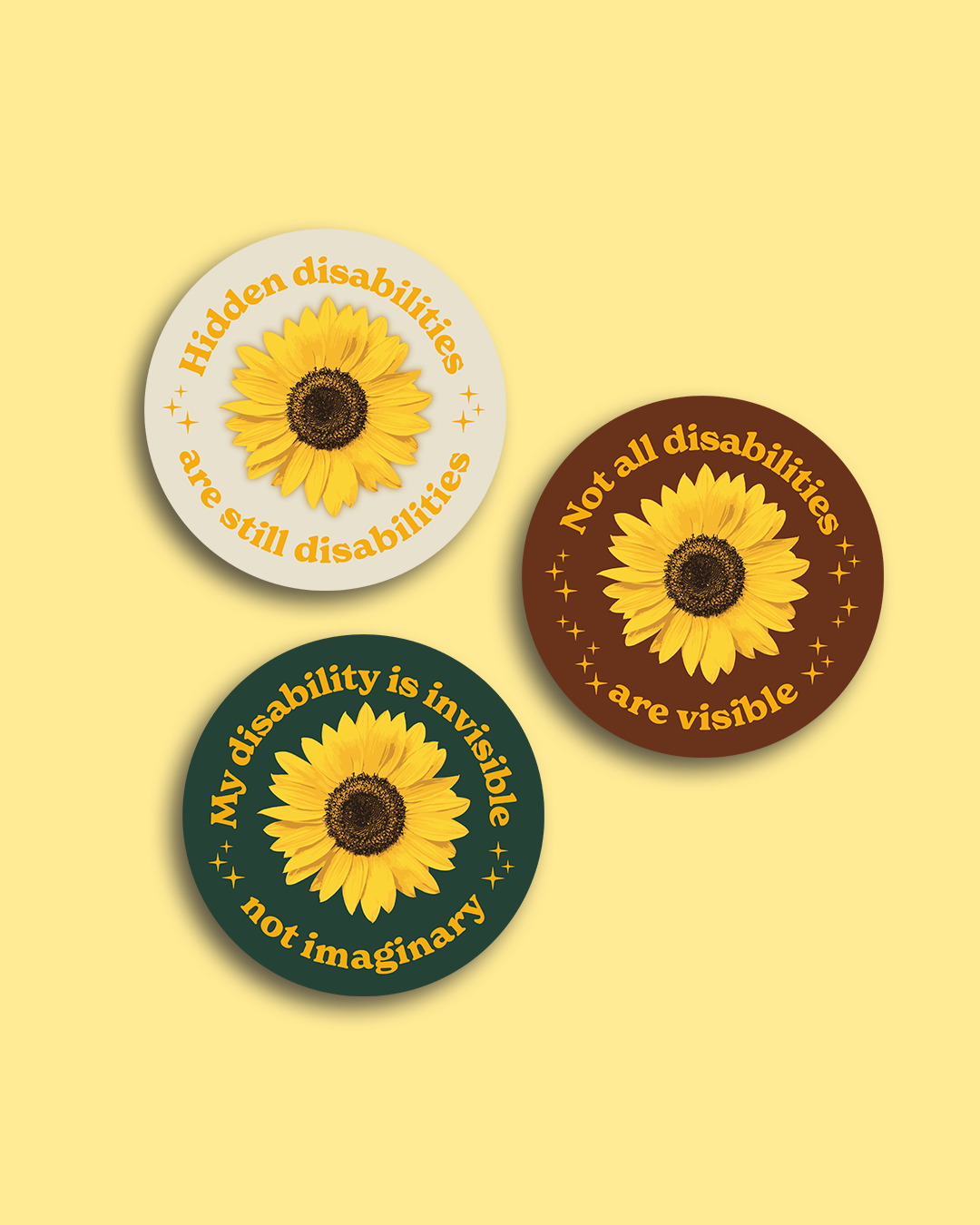 Drei runde Buttons mit Sonnenblumen und Texten in Englisch und Deutsch, die für Sichtbarkeit und Akzeptanz von Behinderungen werben. Die Buttons haben die Farben Weiß, Braun und Dunkelgrün.