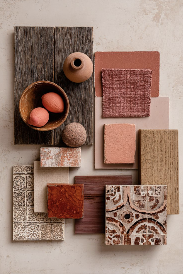 Arrangement of various textured tiles, wood samples, and small decorative objects in earth tones on a neutral background.