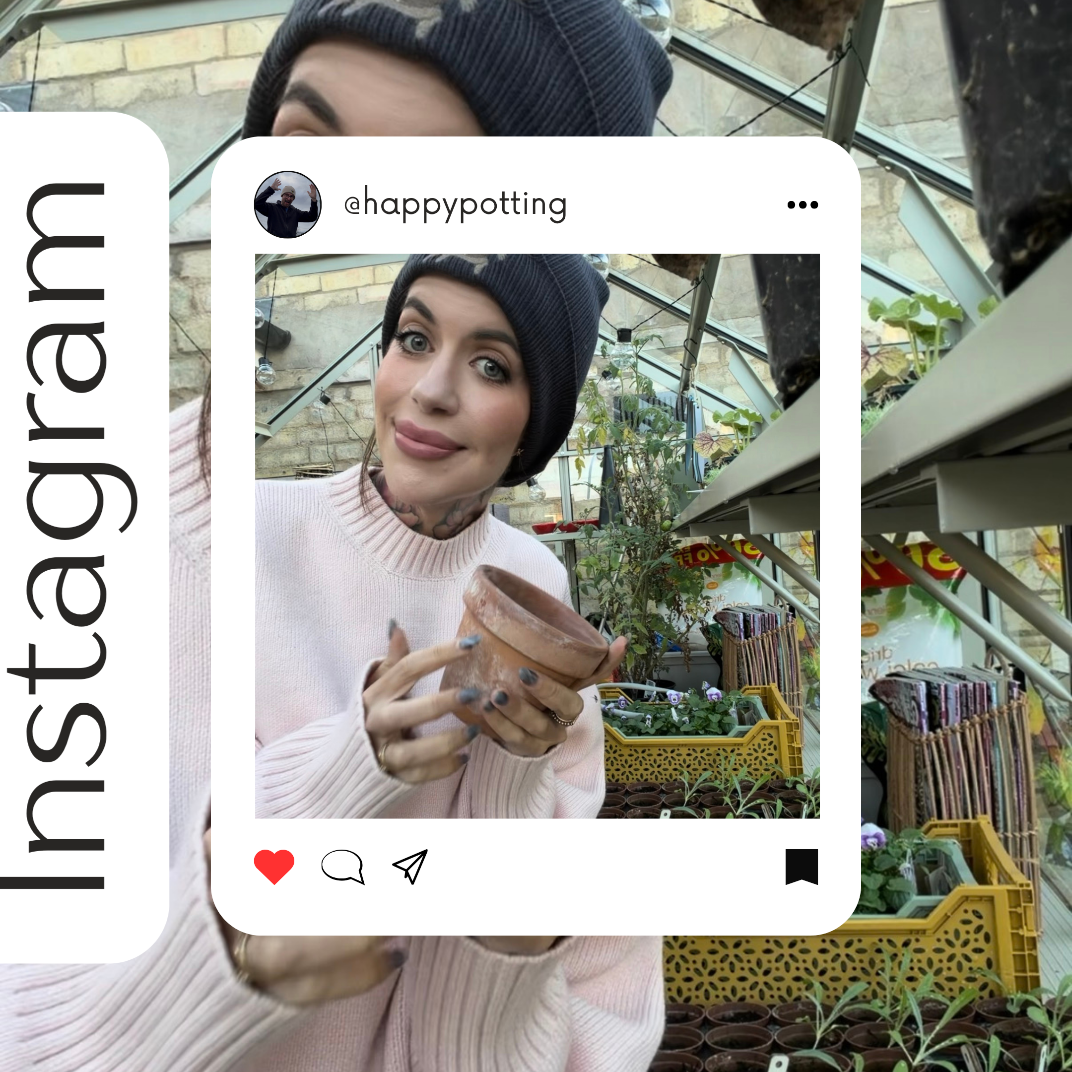 Young woman with tattoos and makeup, wearing a knit cap and light pink sweater, holding a small clay pot inside a greenhouse filled with potted plants and gardening supplies.