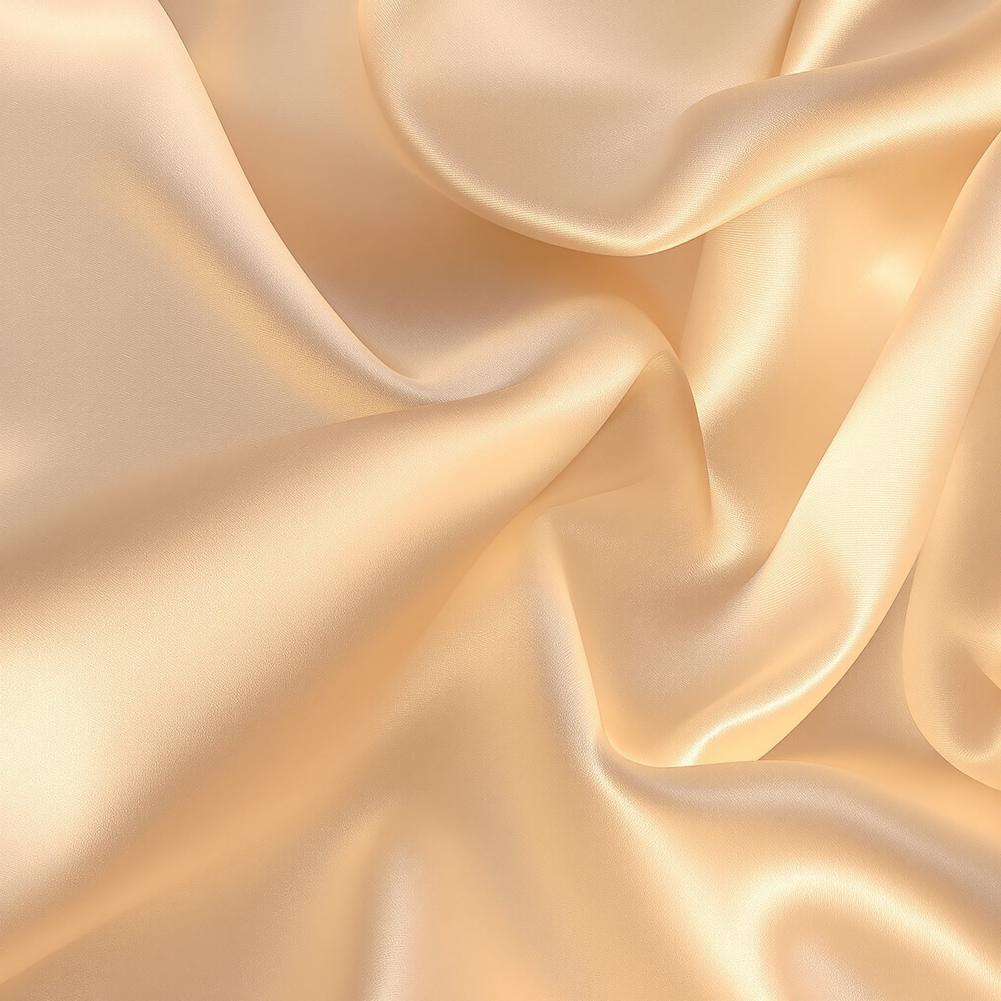 Close-up of smooth, shiny, beige silk fabric with flowing wrinkles.