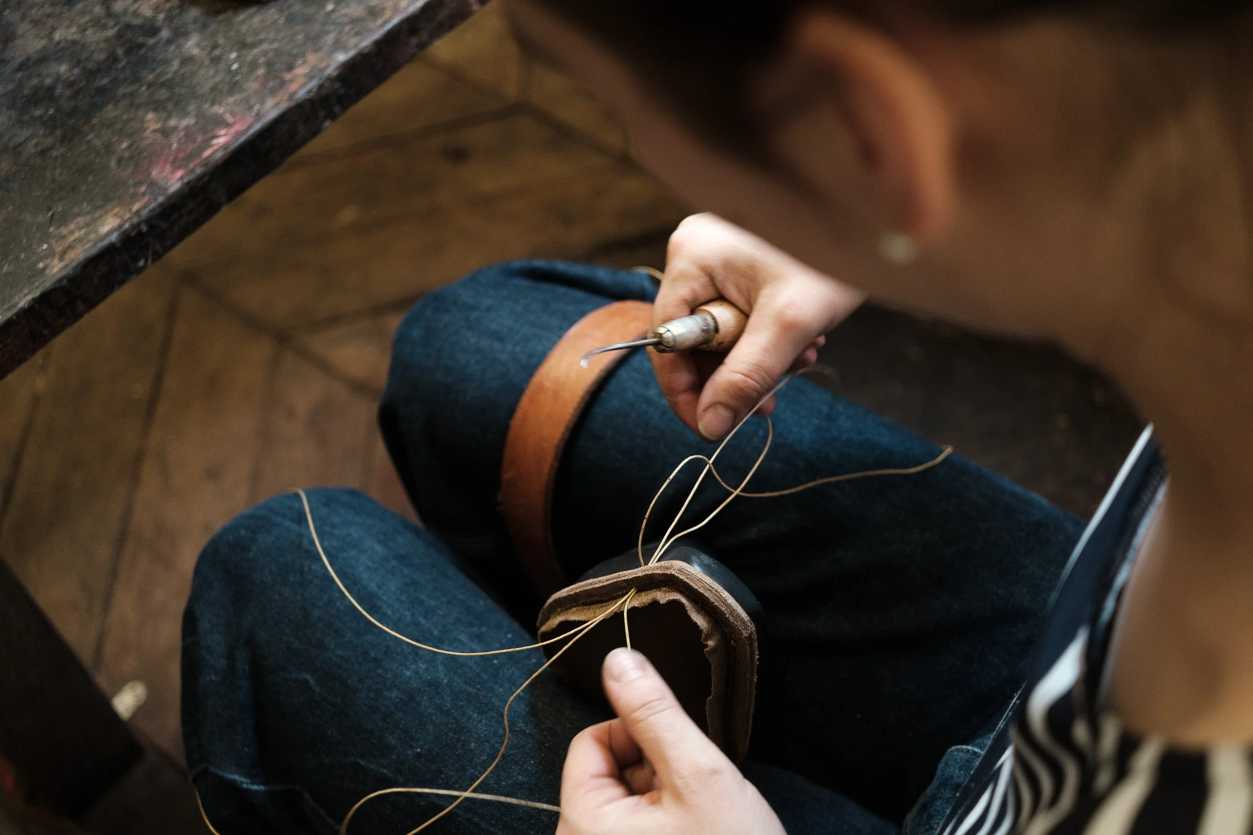 Artisan cousant la semelle d’une chaussure en cuir dans un atelier de fabrication traditionnelle — Guillaume Auray-Runel photographe artisan cuir Normandie