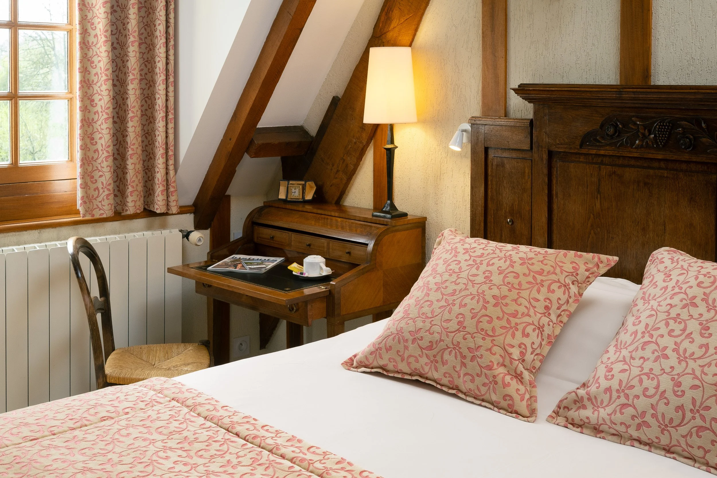 Chambre au style plus rustique et campagne chic, mêlant bureau, lit et éclairage chaleureux — Guillaume Auray-Runel photographe maison d’hôtes Caen