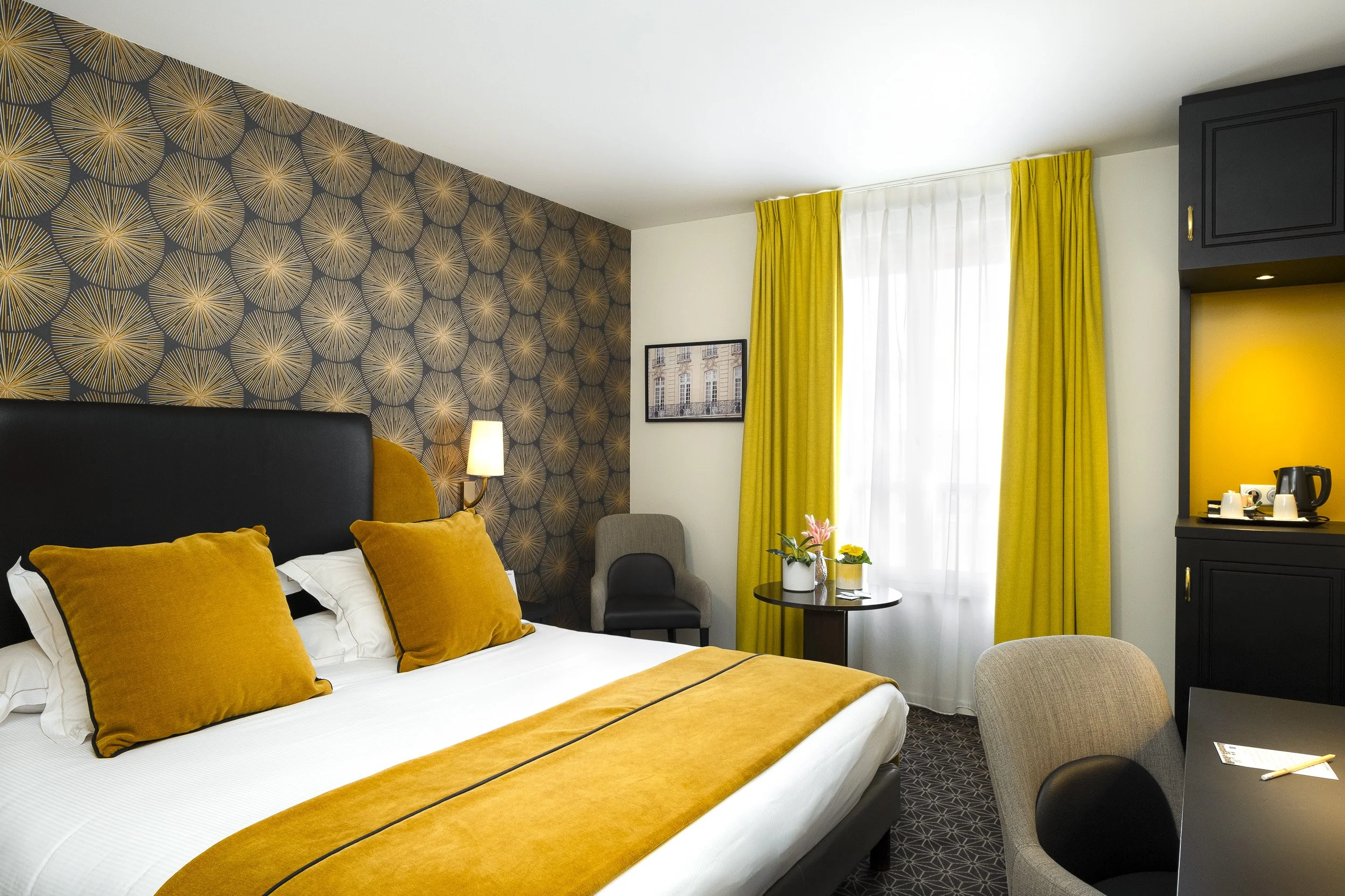 Chambre d’hôtel moderne avec lit, bureau et ouverture vers l’extérieur, lumière naturelle et ambiance apaisante — Guillaume Auray-Runel photographe hôtel Normandie