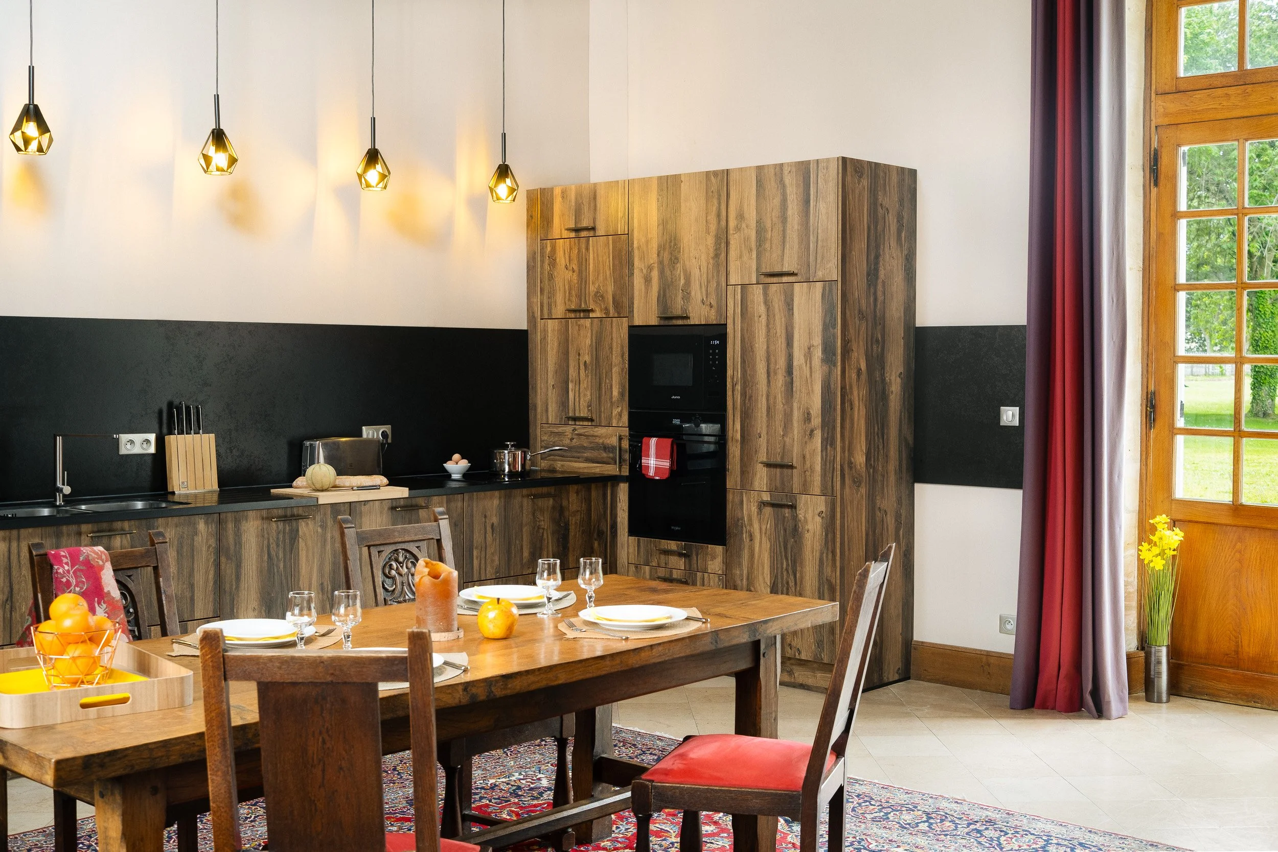 Cuisine avec table dressée pour le déjeuner, scène chaleureuse pensée pour l’accueil des voyageurs — Guillaume Auray-Runel photographe gîte Caen