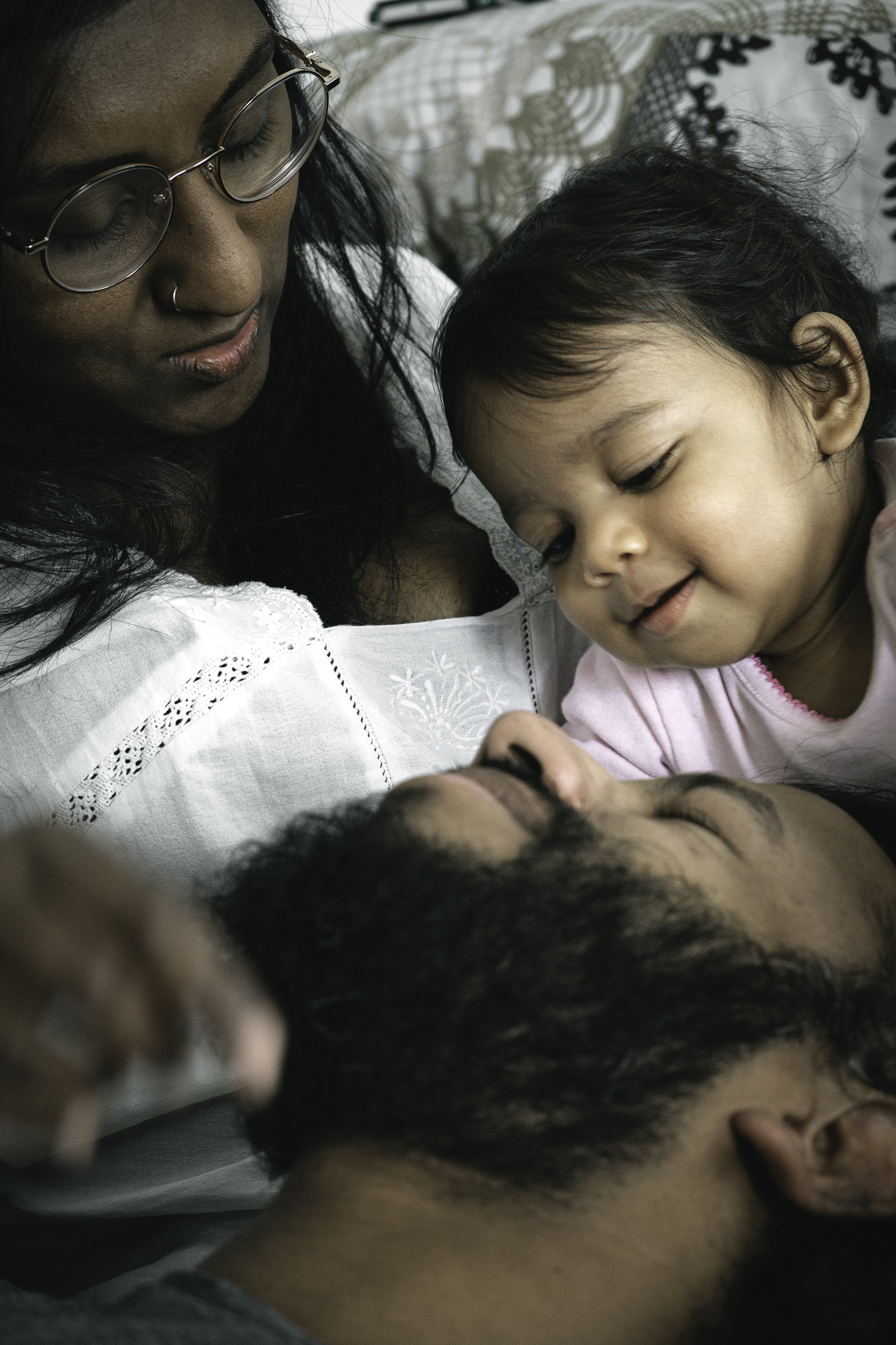 Portrait famille avec bébé grimpant sur le visage de son père, scène tendre et vivante — Guillaume Auray-Runel photographe naissance Caen