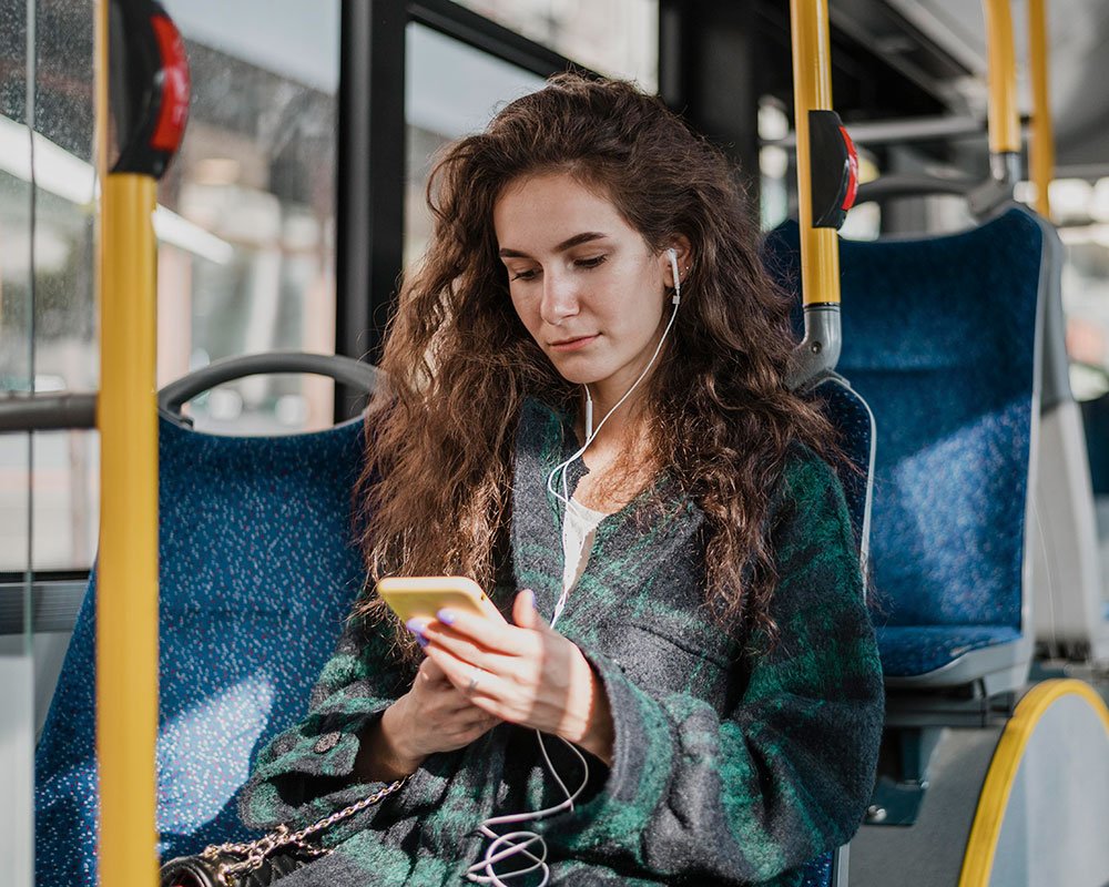 Woman on bus using her phone