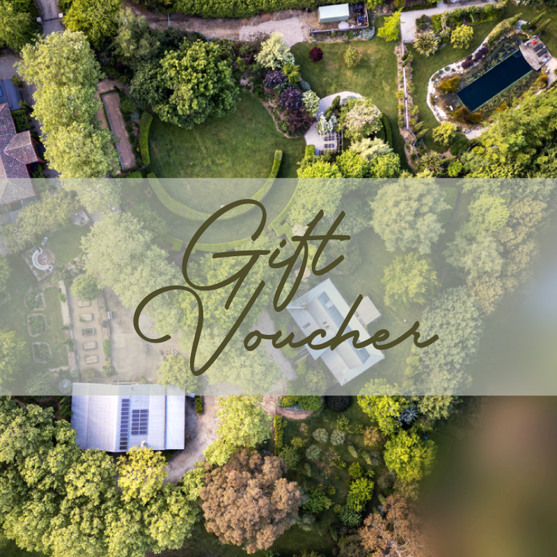 An aerial view of a lush green backyard with trees, a swimming pool, and various garden features. The image has a semi-transparent overlay with the words "Gift Voucher" written in elegant script.