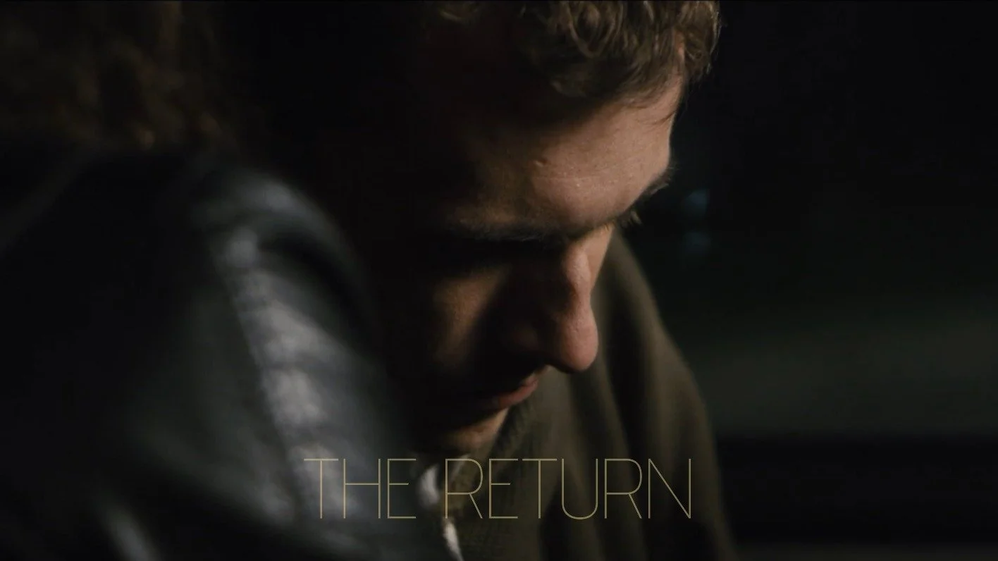 Close-up of a man looking downward with a serious expression, wearing a leather jacket, with text 'THE RETURN' at the bottom.