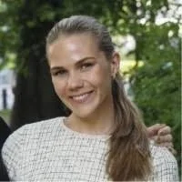 A woman smiling outdoors with trees in the background. Karoline Aamodt Foss.