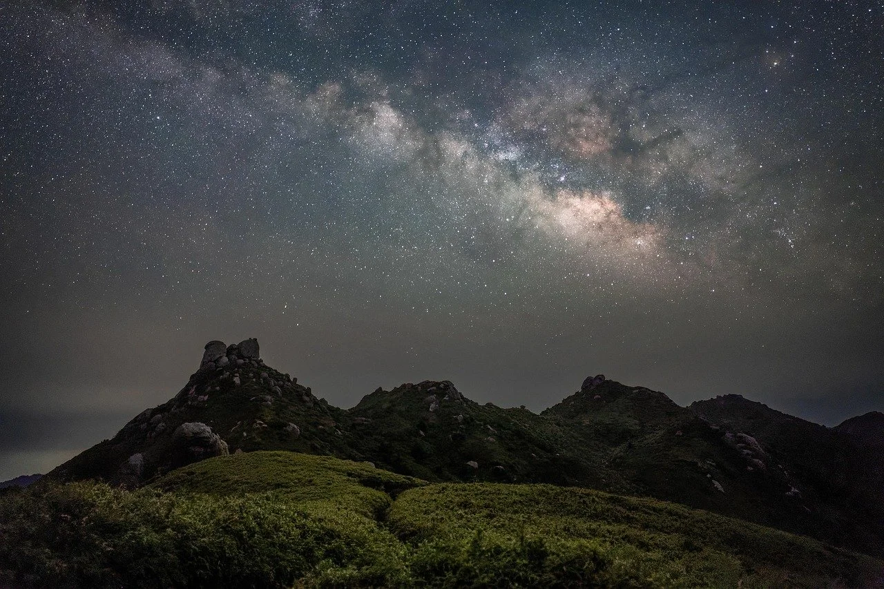 Night sky with the Milky Way above mountains representing the soul’s life path and natal chart.