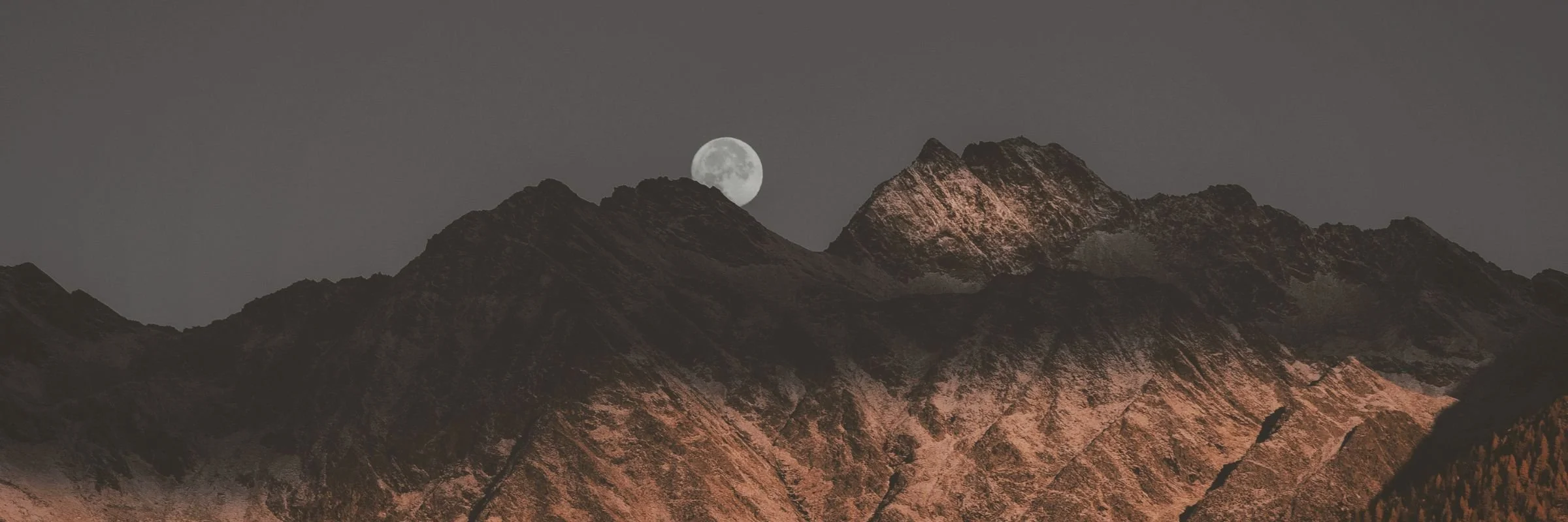 Mountain peak with moon above symbolising cycles and soul evolution at Evolutionary Astrology Academy
