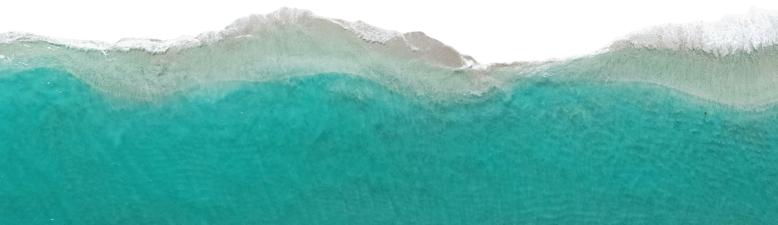 Aerial view of turquoise ocean waves breaking softly onto the shore.