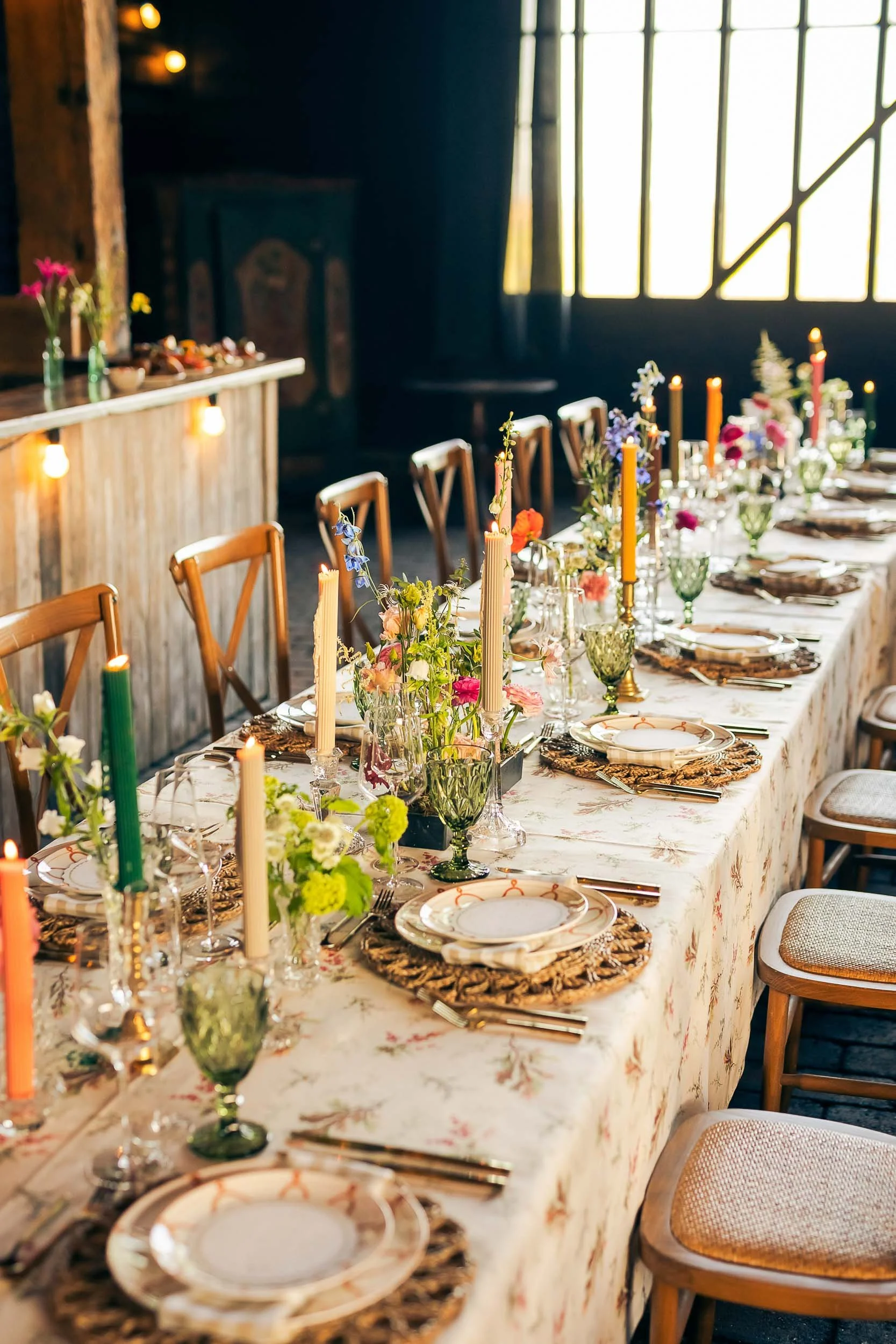 Scenic view of a lake surrounded by green hills and mountains under cloudy sky.