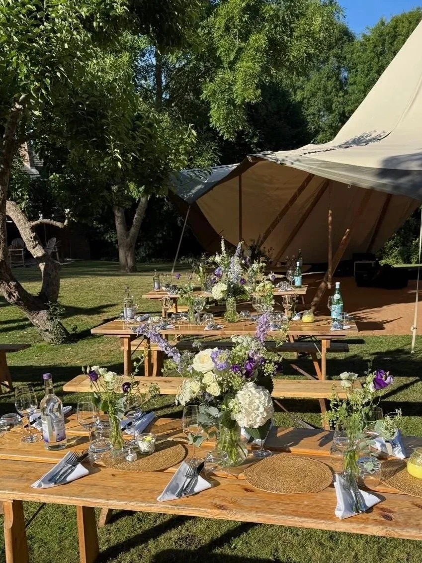 Scenic view of a lake surrounded by green hills and mountains under cloudy sky.