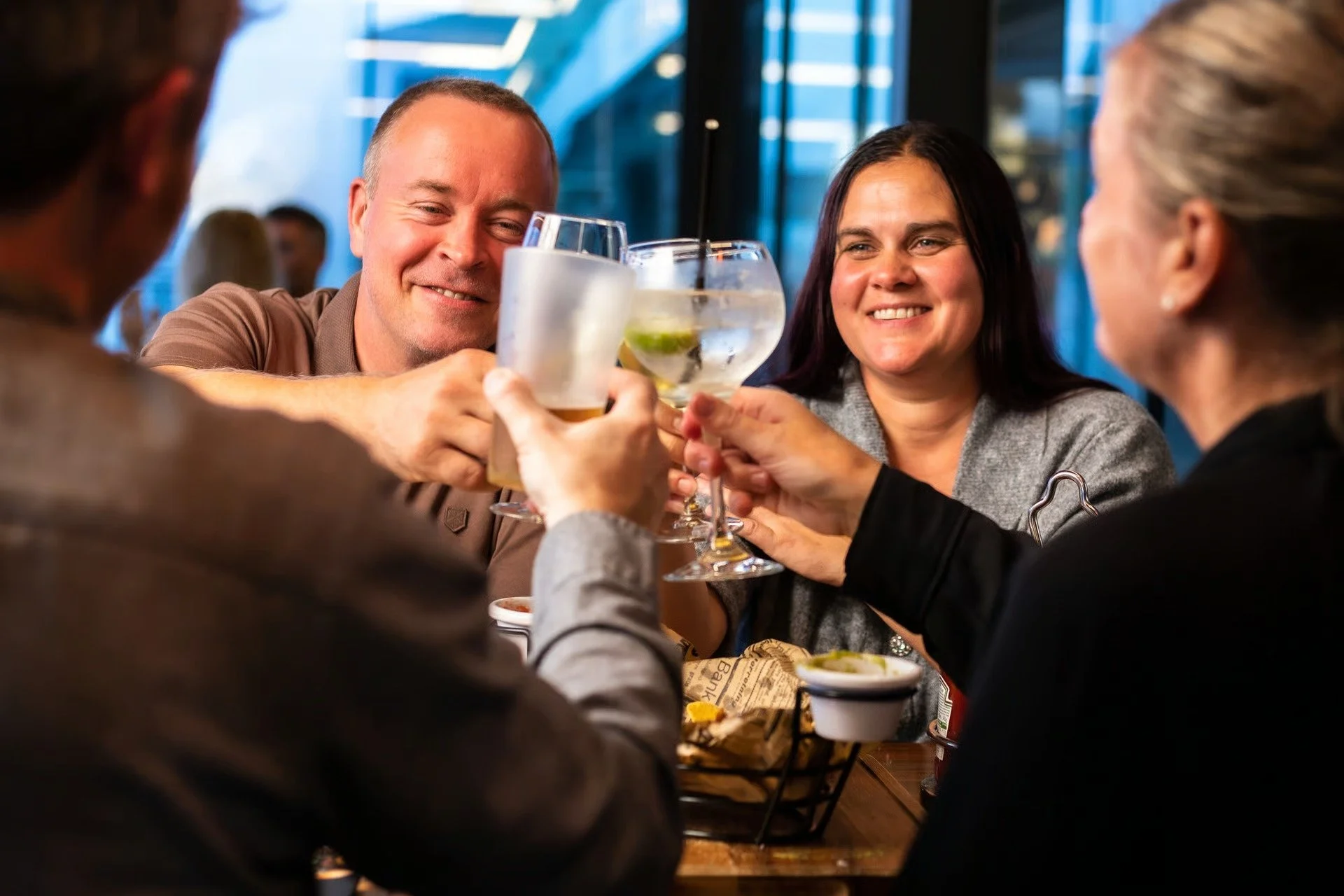 Bilde av folk som holder drinker og skåler og smiler