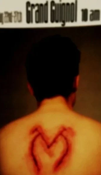 A person with a heart drawn on their back with a marker.
