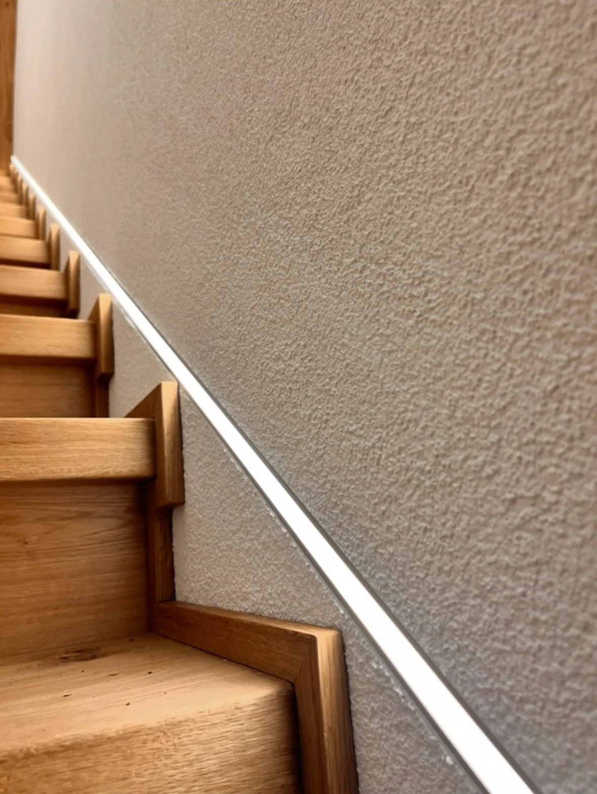 Holztreppe mit Geländer und beige Wandanstrich.