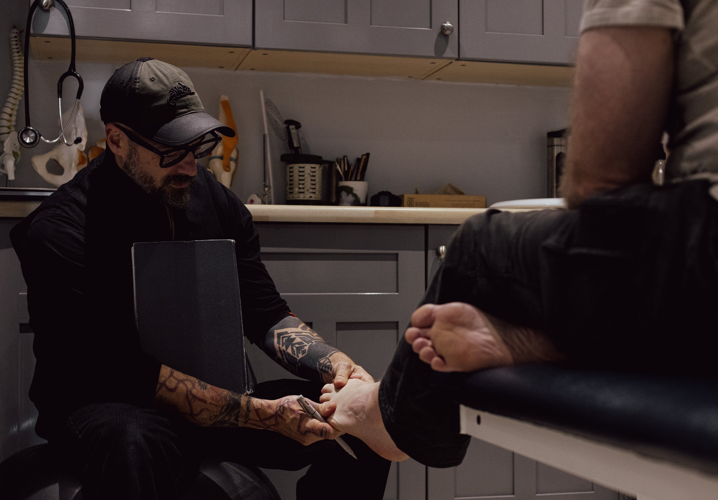A man checking another man foot in a clinical environment for a initial assessment.