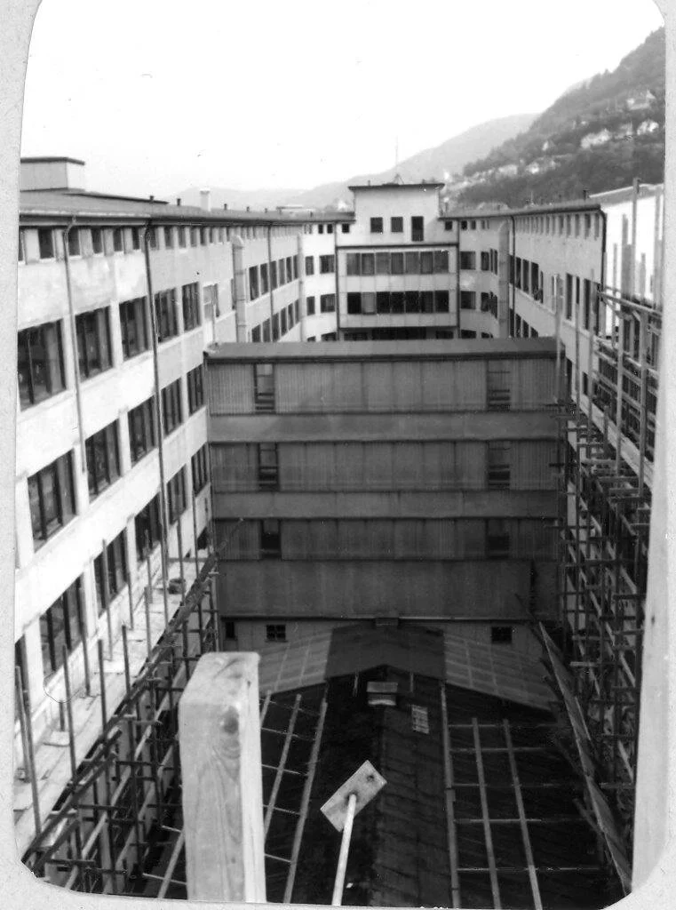 Bygning under oppføring eller renovering med byggematerialer og stillas.