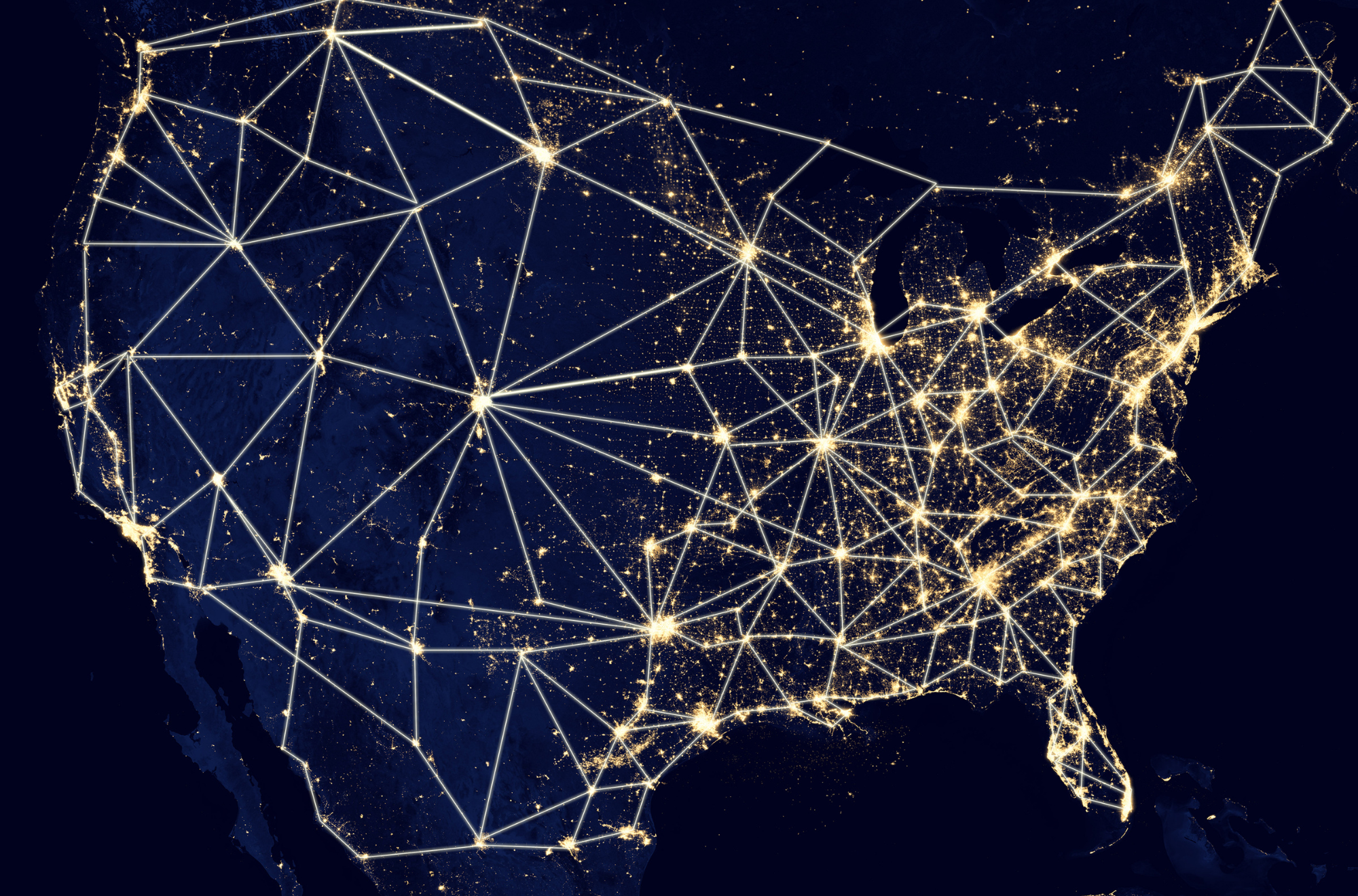 A satellite view of North America at night showing a network of glowing lines and dots representing digital connectivity and infrastructure across the continent.