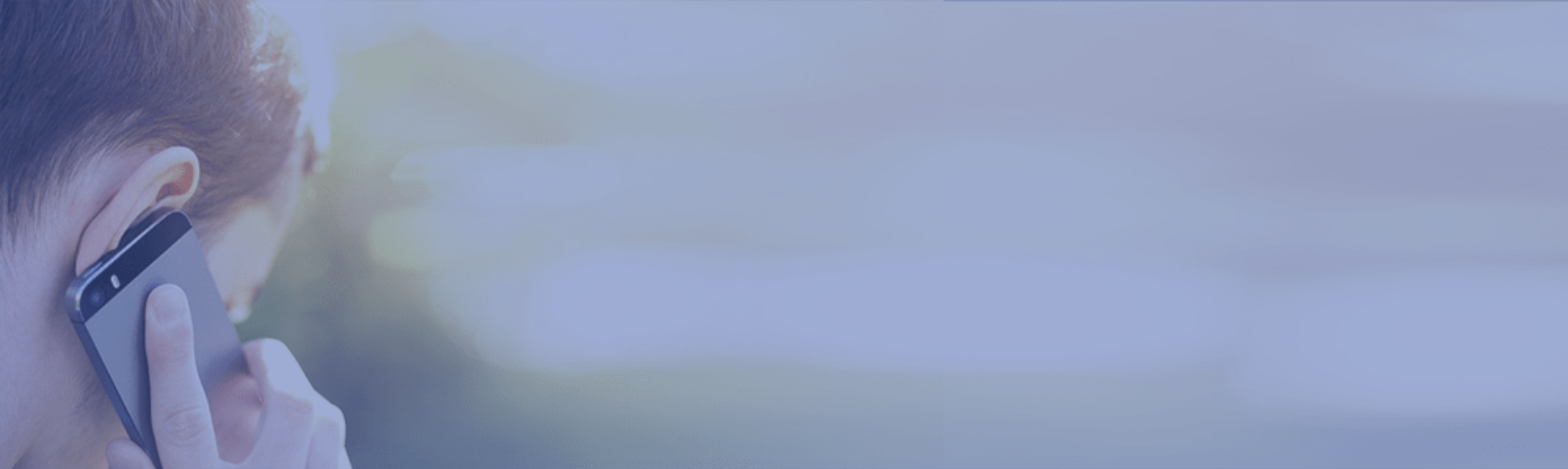 Person talking on a cell phone outdoors with a blurred background.