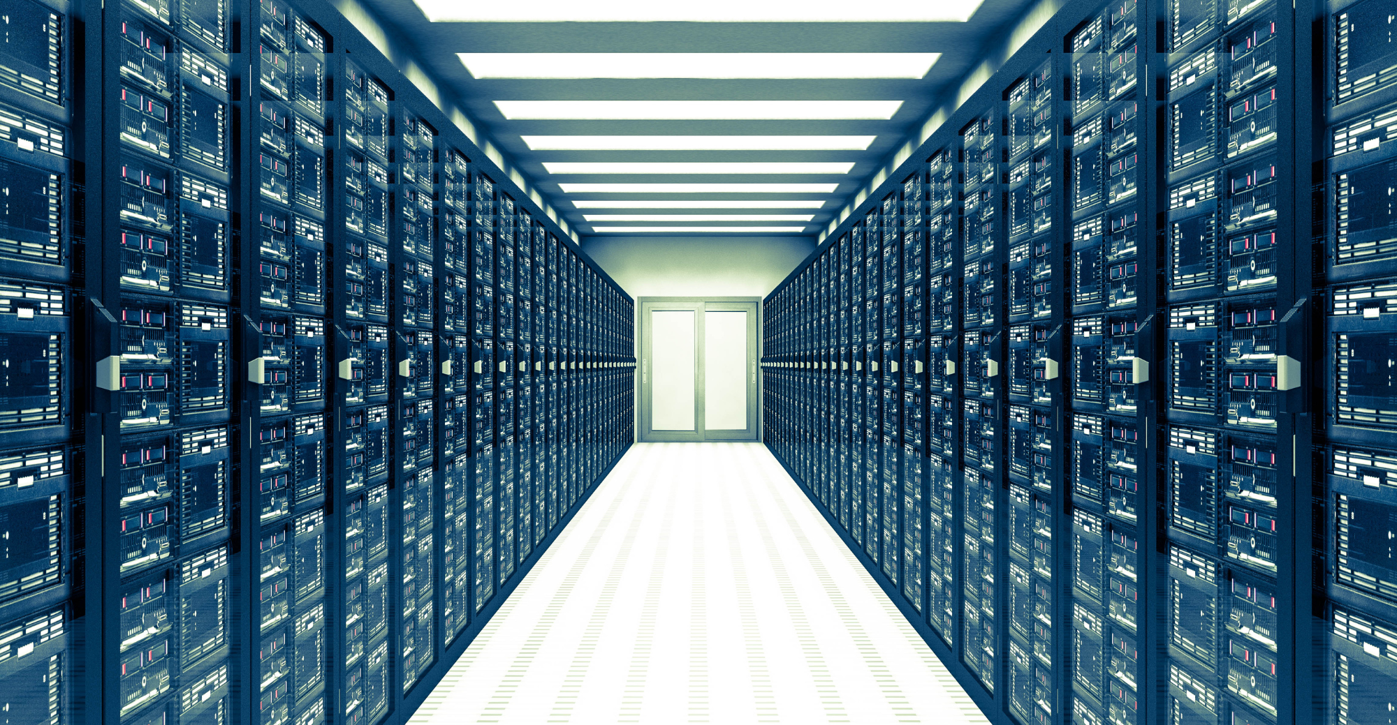 Data center hallway with rows of server racks on each side and a door at the end, illuminated by overhead fluorescent lights.