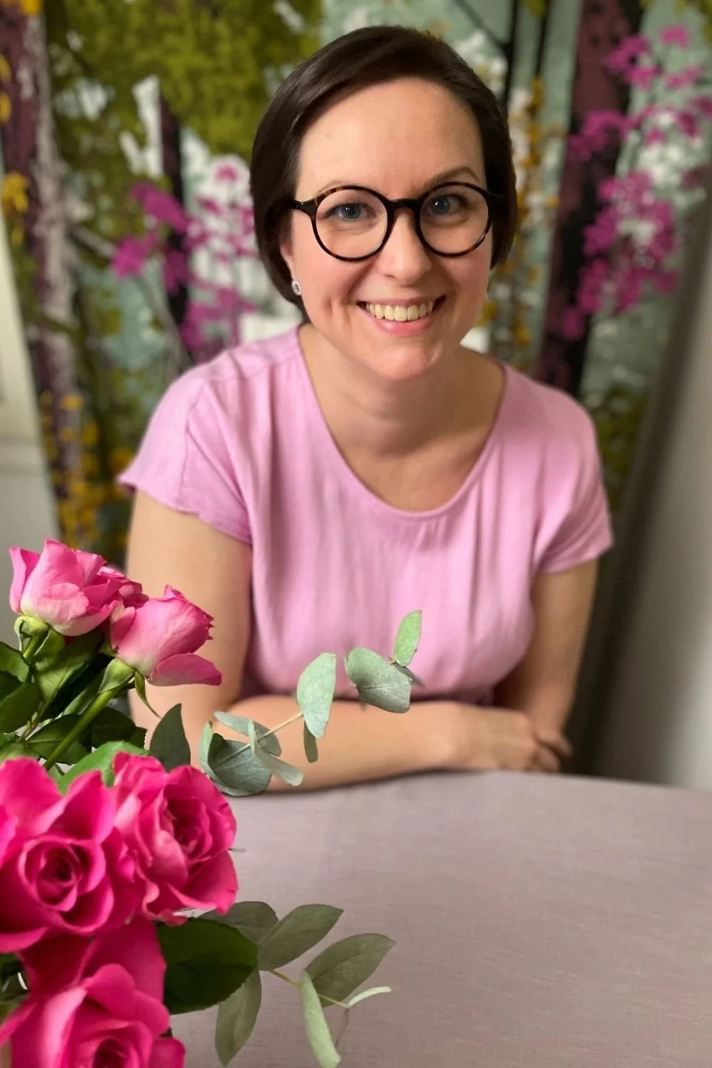 Lastenhoitajanainen hymyilee kameralle.