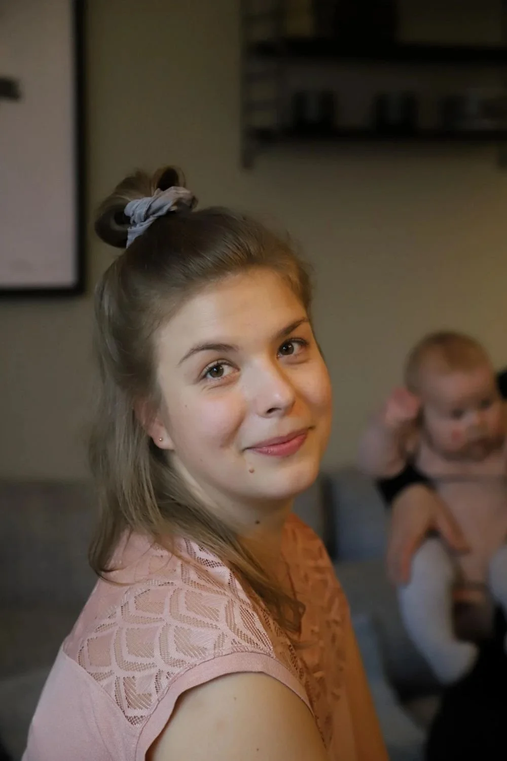 Lastenhoitaja hymyilee kameralle.