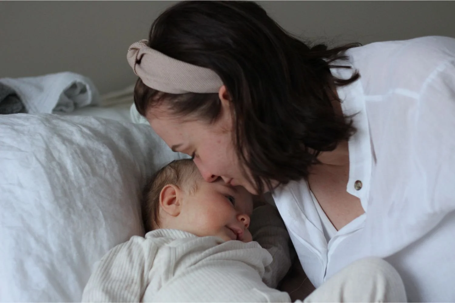 Äiti pussaa vauvaa otsalle